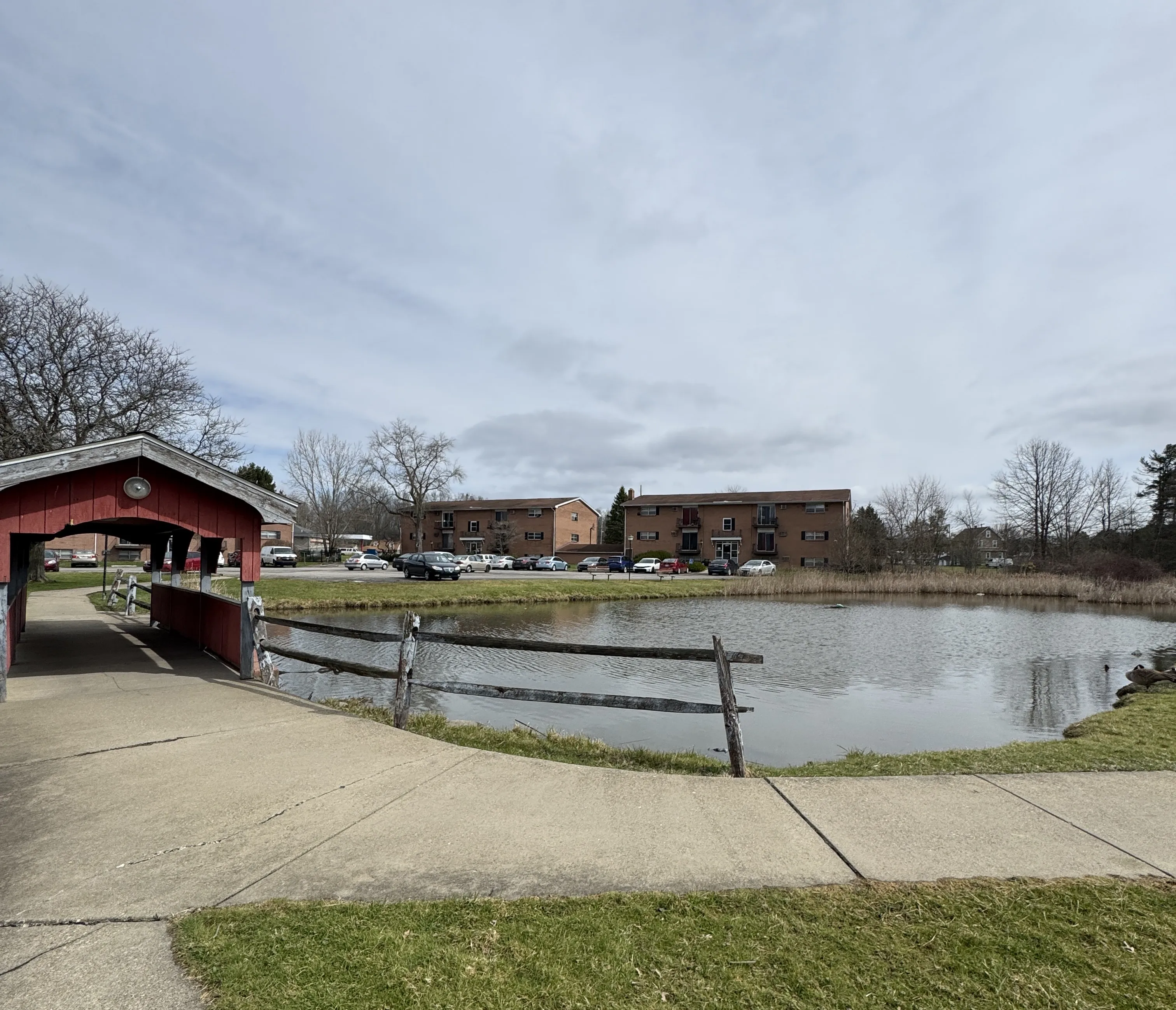 Close view of the red covered bridge over the pond.